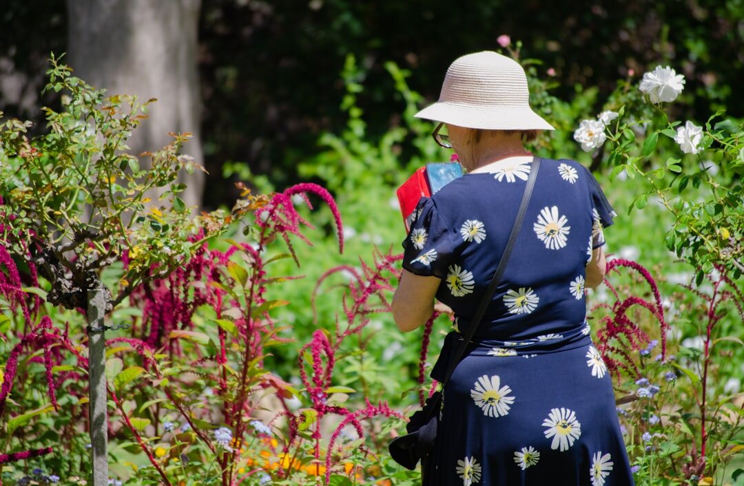 Czech woman in her fifties planting flowers near a countryside cottage